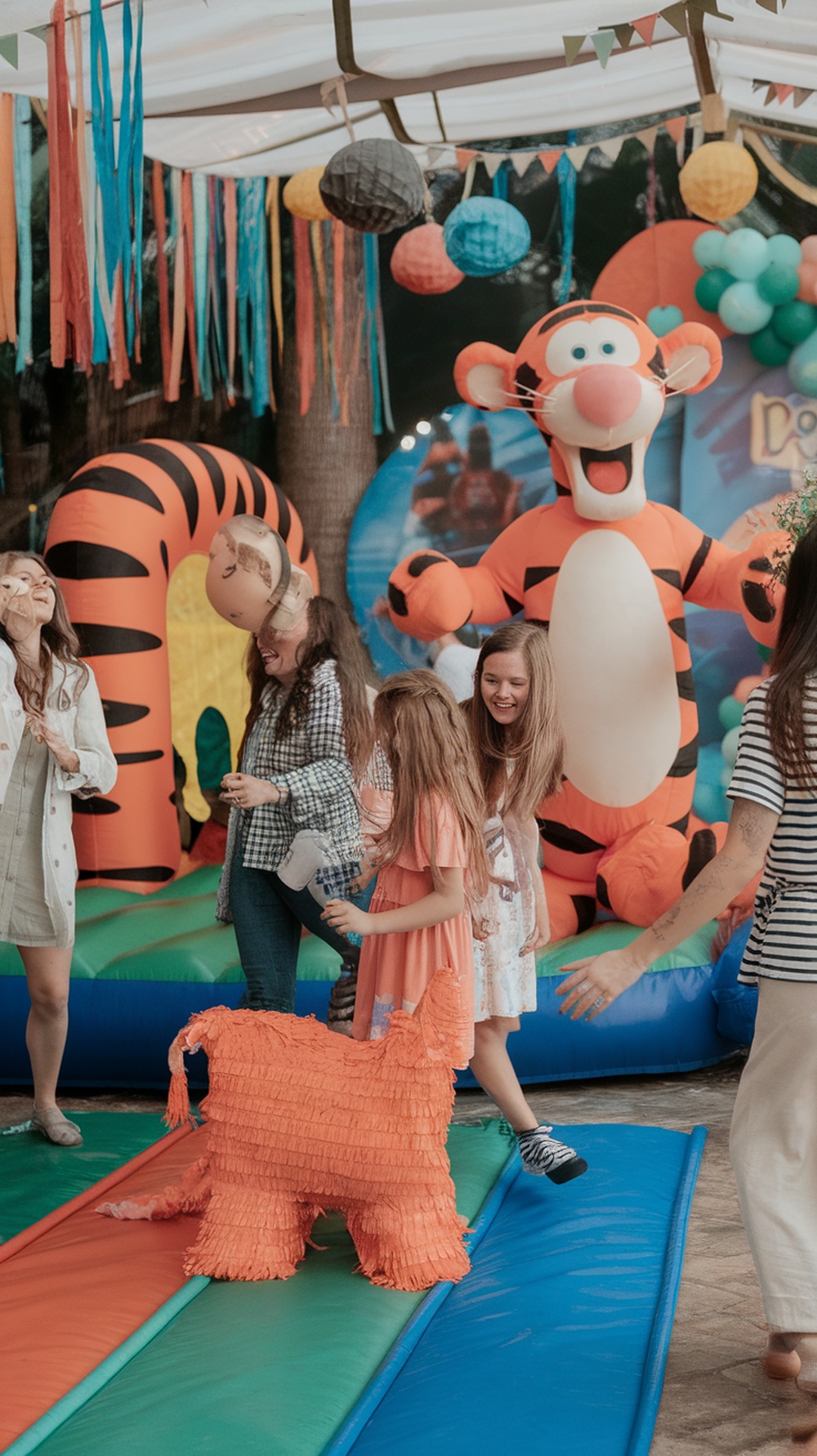 Children enjoying a Tigger-themed bounce house at a baby shower.
